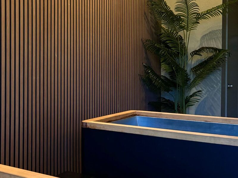 Cold plunge tub with string lights and warm amber tones at Flowstate